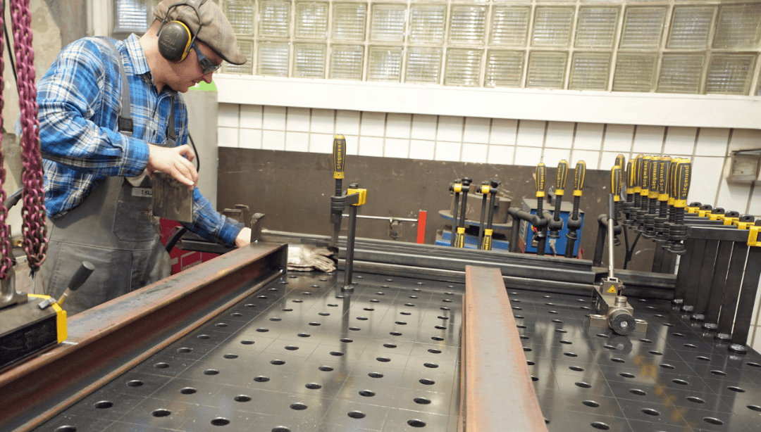 Schweißer bei Metallverbindung mit Stahl- und Schweißtechnik, präzise Arbeit in einem Werkstattumfeld.