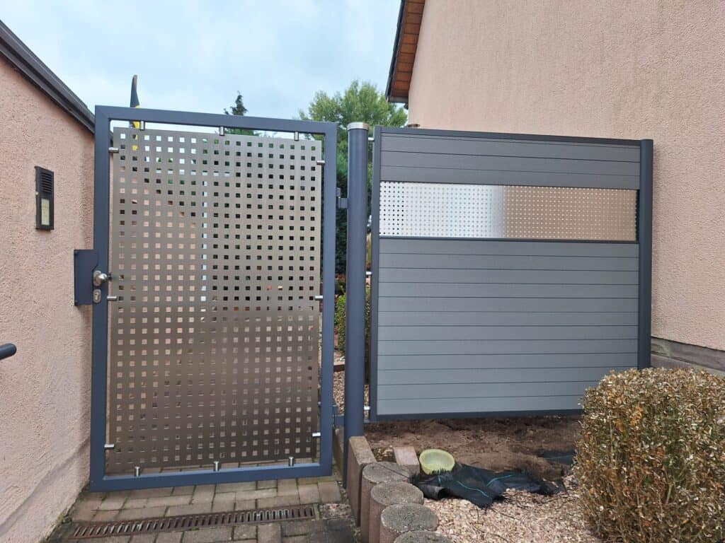 Vielseitiger Metallzaun mit modernen Design, kombiniert aus perforiertem und satiniertem Stahl, sorgt für Sicherheit und Ästhetik im Garten. Hochwertige Stahl- und Schweißtechnik garantiert langlebigen Schutz.